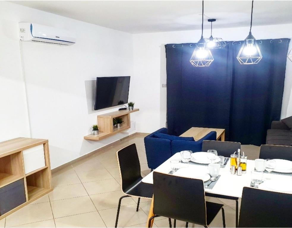 een eetkamer met een tafel en een blauw gordijn bij Secondhome102 in Paphos City