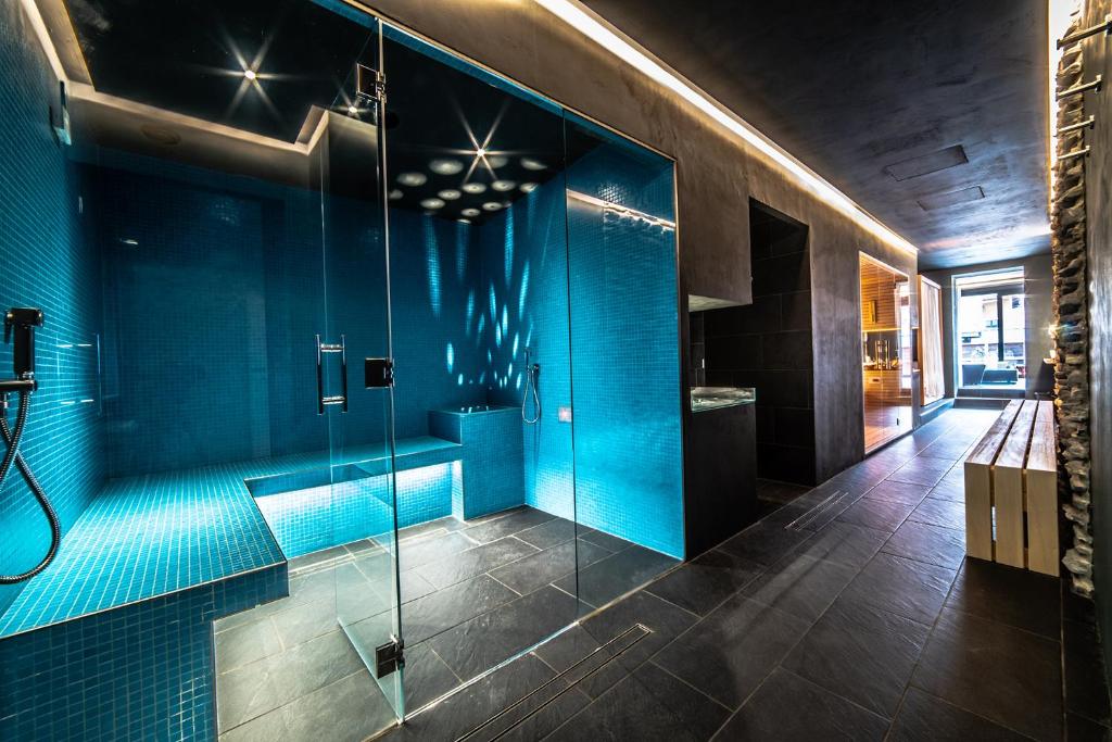 an empty room with a shower and a blue wall at HB Aosta Hotel & Balcony SPA in Aosta