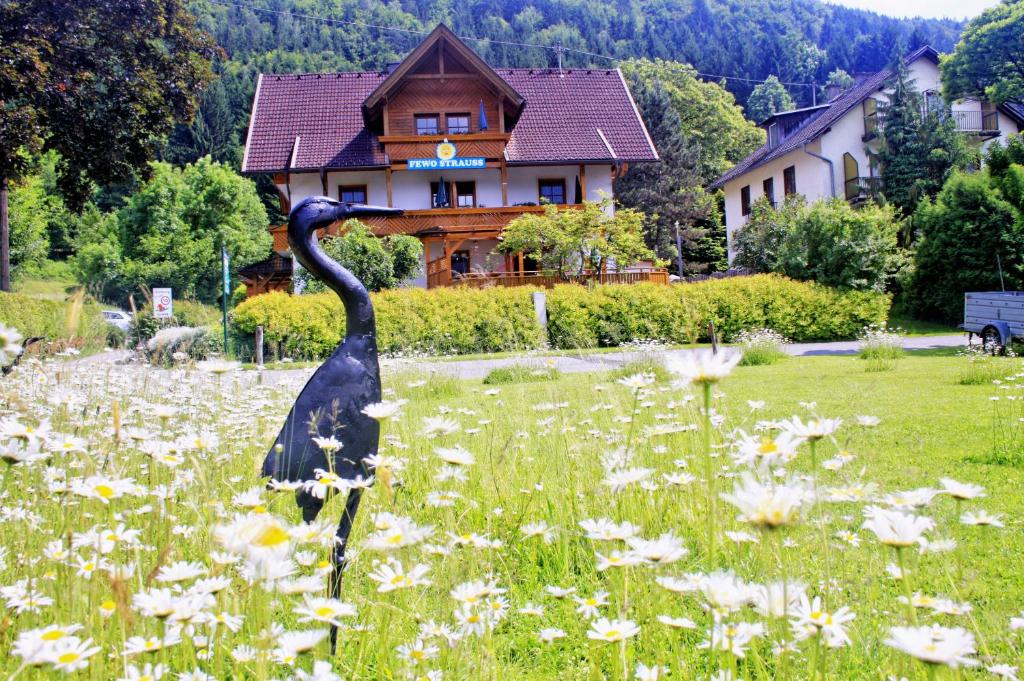 a statue of a bird standing in a field of flowers at Fewo Strauss in Ossiach