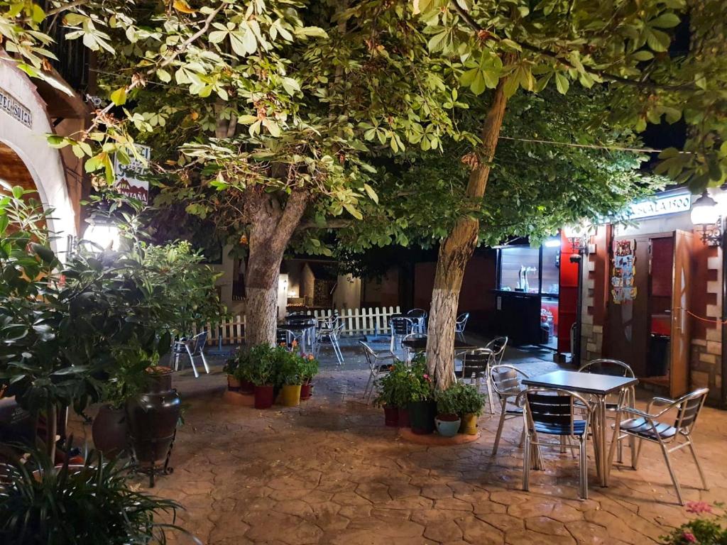 ein Restaurant mit Tischen, Stühlen und Bäumen in der Unterkunft Hotel Suiza in Bronchales