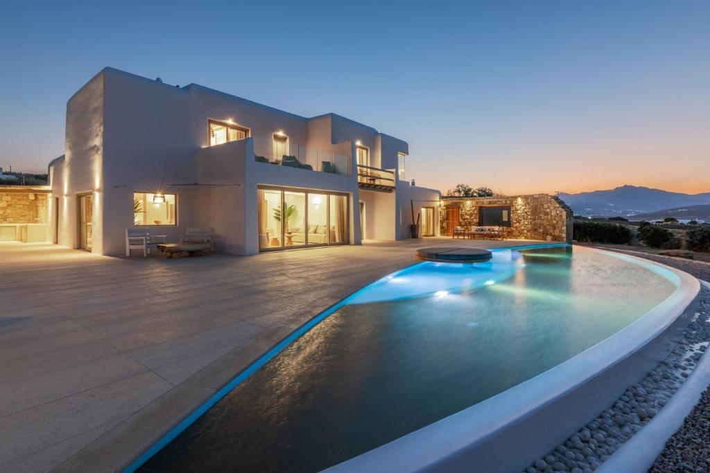 a villa with a swimming pool in front of a house at Mykonos AG Villas in Elia