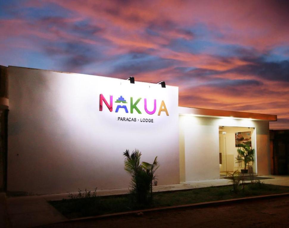 aania sign on the side of a building with a sunset at Nakua Paracas Lodge in Paracas