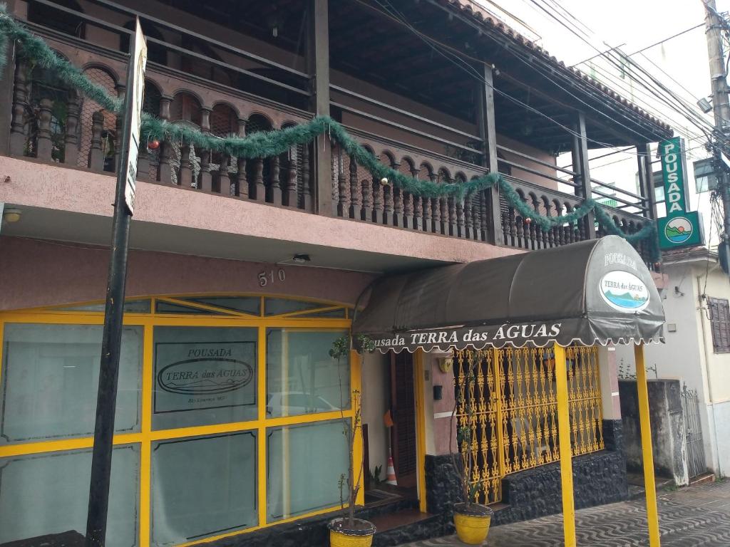 um edifício com um guarda-chuva em frente em Pousada Terra das Águas em São Lourenço