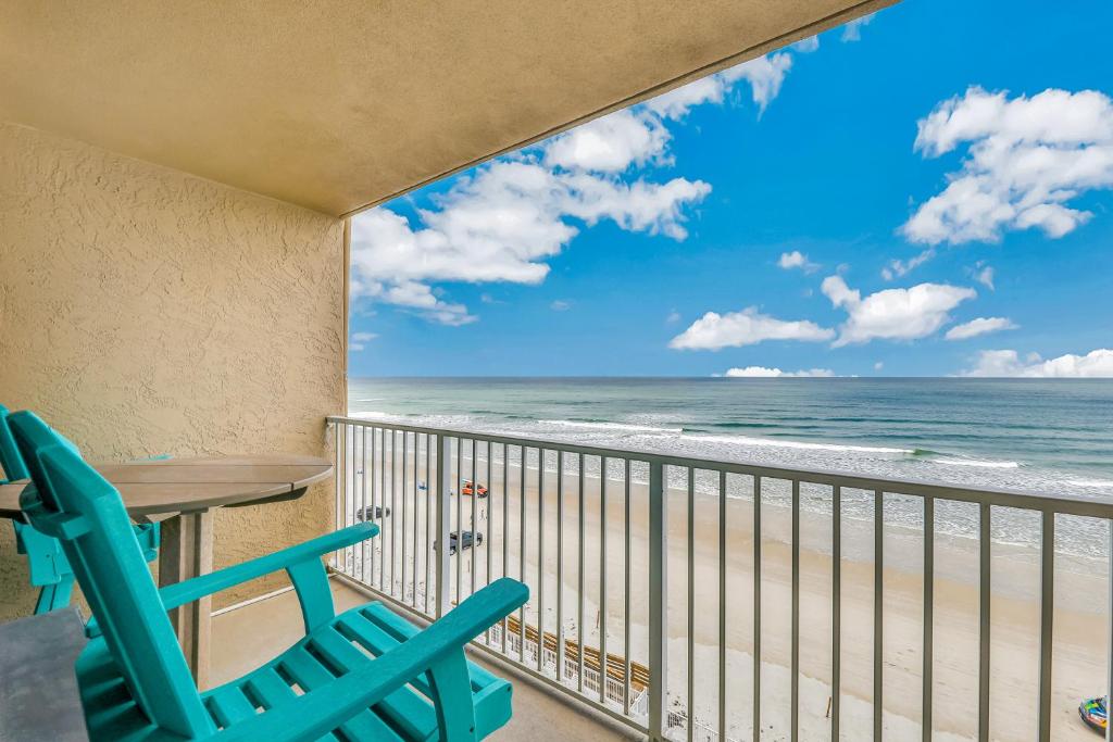 balcón con mesa y sillas y la playa en Sunshine & Oceanfront Serenity, en Daytona Beach Shores