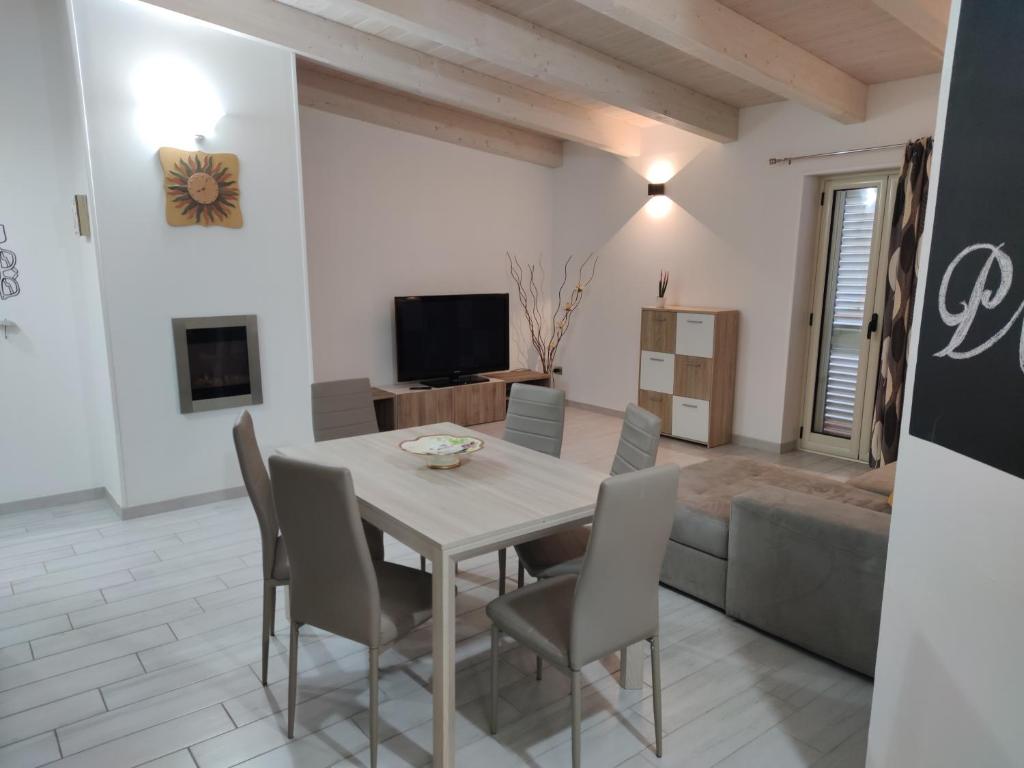 a dining room with a table and chairs and a couch at Planet apartments 1 in Montalbano Jonico