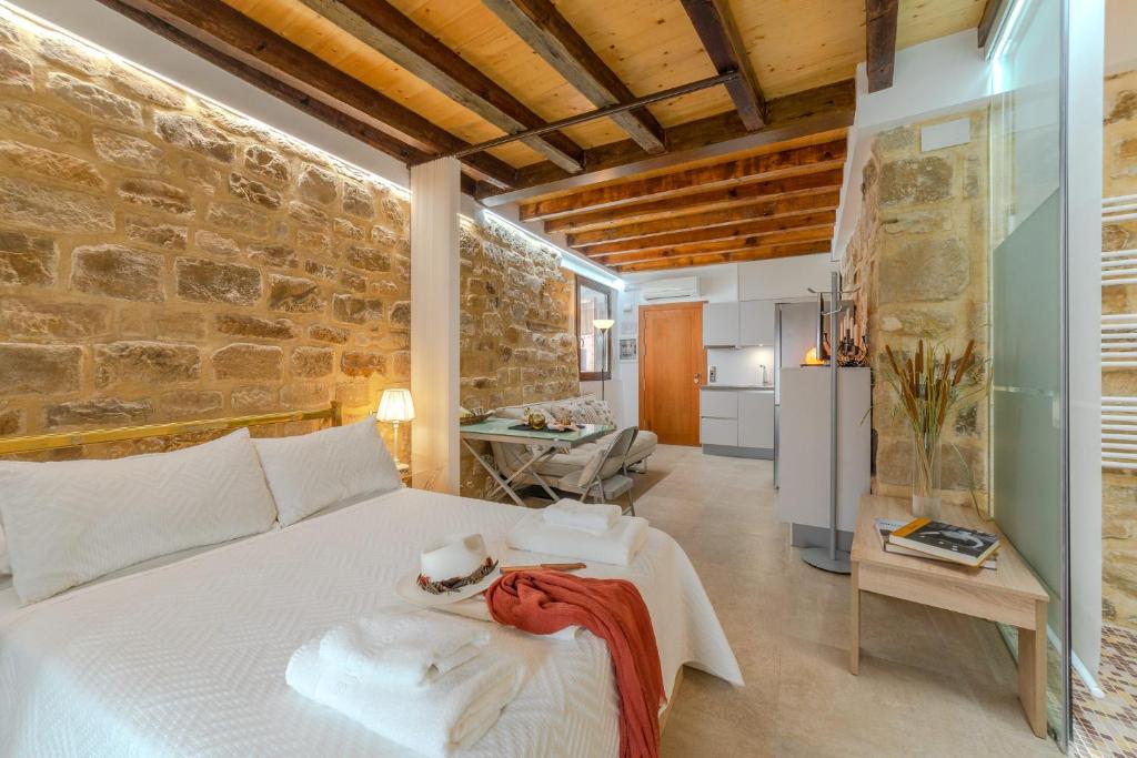a bedroom with a bed and a stone wall at Apartamentos “Quotidianum” in Úbeda
