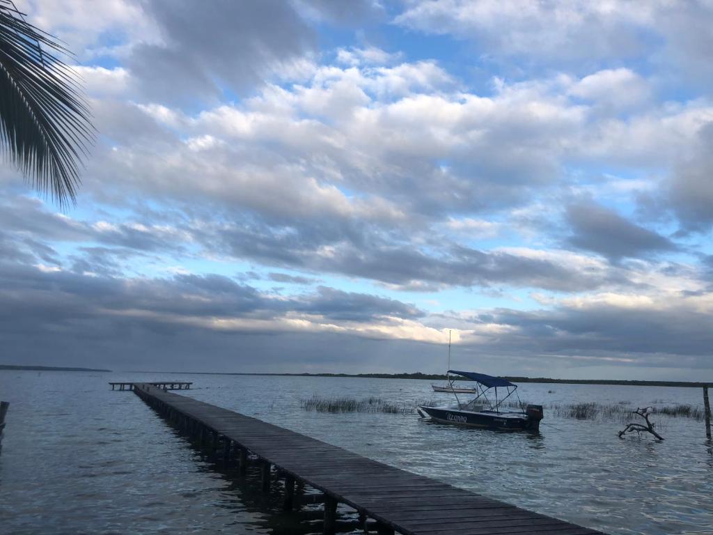 a boat sitting on the water next to a dock at Departamentos Blue Bacalar in Bacalar