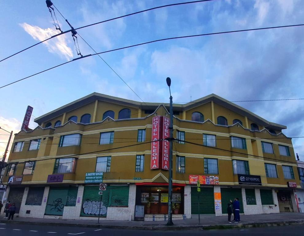 un edificio amarillo en la esquina de una calle en Hotel Allegria, en Quito