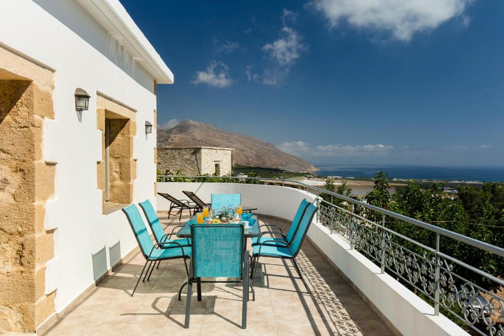a balcony with a table and chairs and the ocean at Basilikos traditional house, 10' from Falasarna in Kissamos