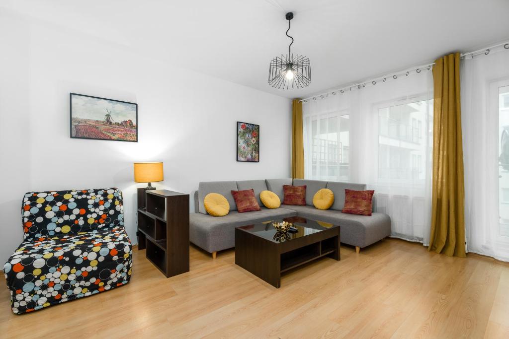 salon z kanapą i stołem w obiekcie Sleepway Apartments - Garbary 95-78 w Poznaniu