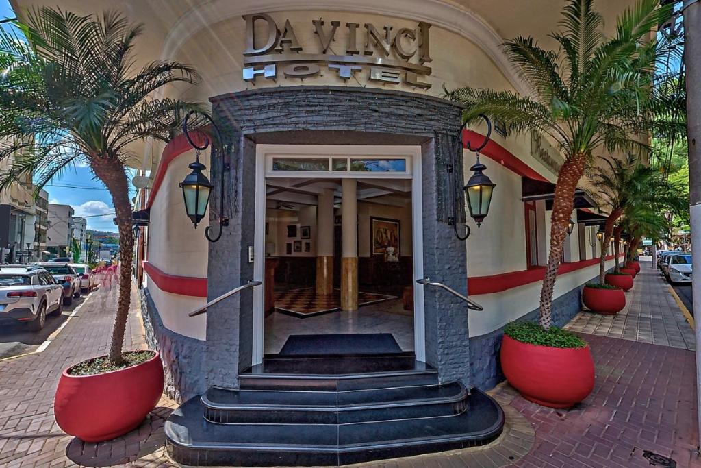 un hotel con palmeras frente a un edificio en Hotel Da Vinci, en Serra Negra