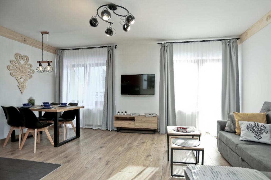 Televízia a/alebo spoločenská miestnosť v ubytovaní ZakoApartament Brzozowa