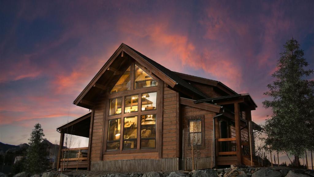 a house with large windows and a cloudy sky at Relax in Luxury - Jacuzzi, Indoor/Outdoor Fireplace in Estes Park