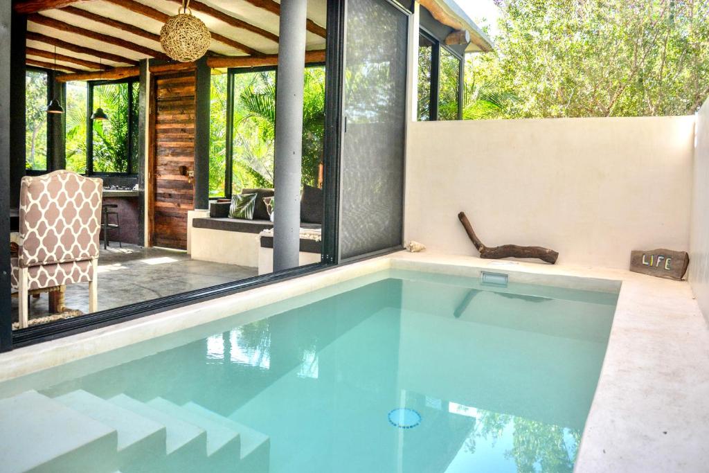 una piscina en medio de una casa en Villa Feronia Tulum, en Tulum