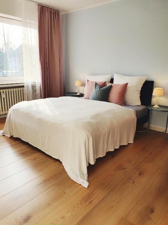 a bedroom with a large bed with pillows on it at Harmony Apartment in Gelsenkirchen