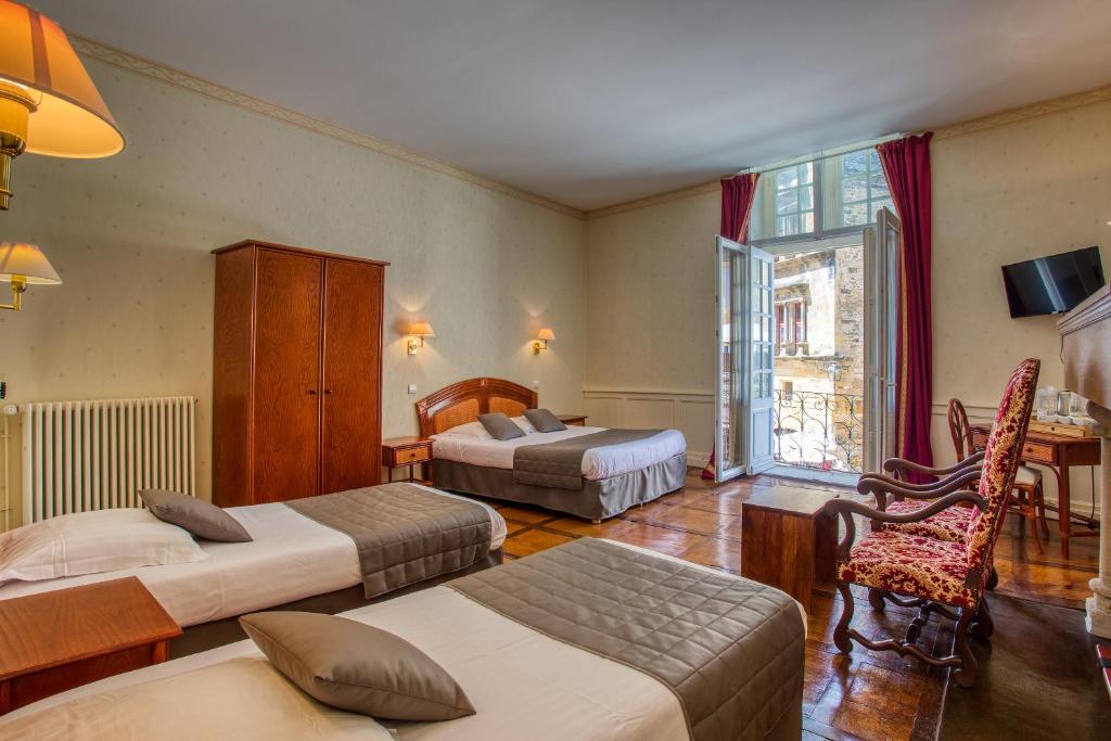 a hotel room with two beds and a desk at Noreli B&B in Sarlat-la-Canéda