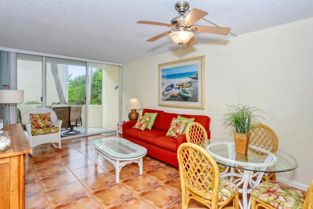 a living room with a red couch and a table at LaPlaya 104E Perfectly located near the path to the beach just steps from the pool in Longboat Key
