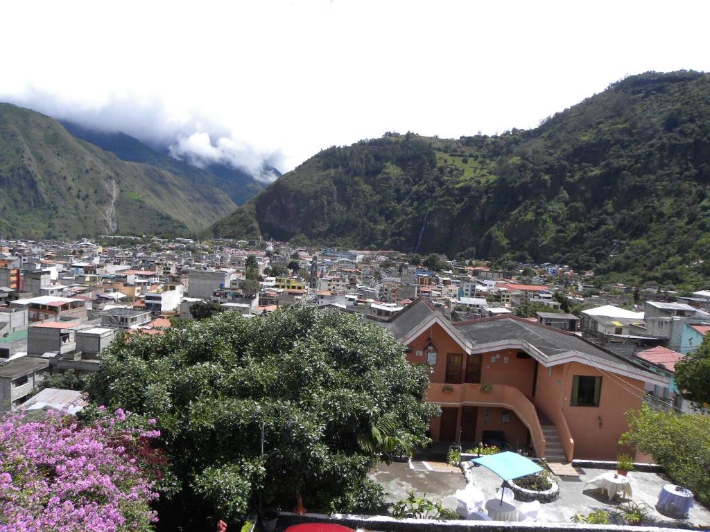 a view of a city with mountains in the background at Hosteria Llanovientos in Baños