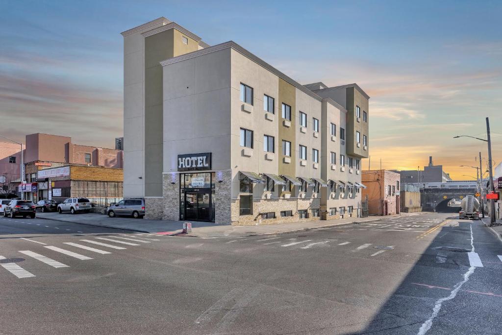 una strada vuota in una città con un edificio di Hotel Pergola Jamaica JFK a Queens