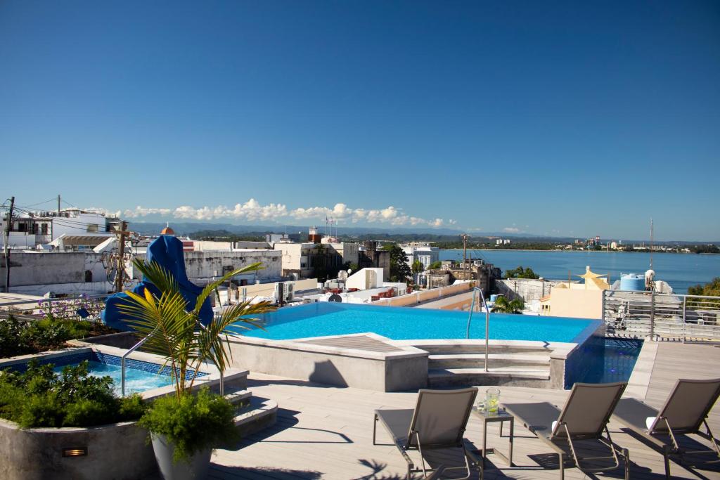 a pool with chairs and a view of the water at Palacio Provincial - Adults Only in San Juan