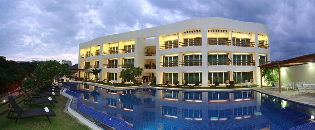 a large building with a swimming pool in front of it at Princess Mayev in Santa Cruz Huatulco