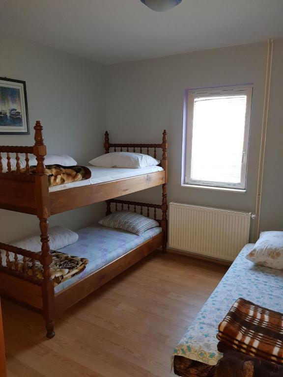 Un dormitorio con dos literas y una ventana. en Zlatiborska jutra, en Zlatibor
