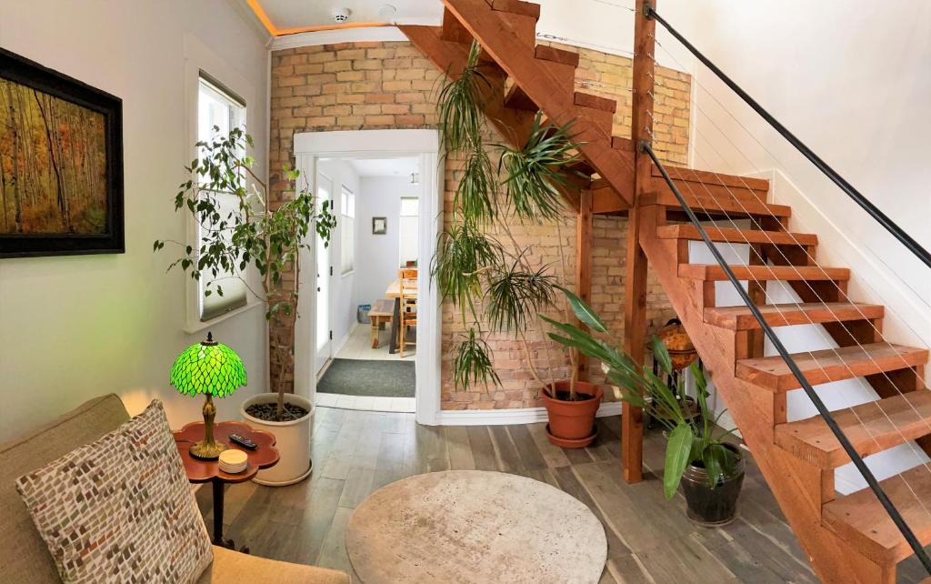 a living room with a staircase and a brick wall at The Elm Tree Cottage in the Sugarhouse District in Salt Lake City