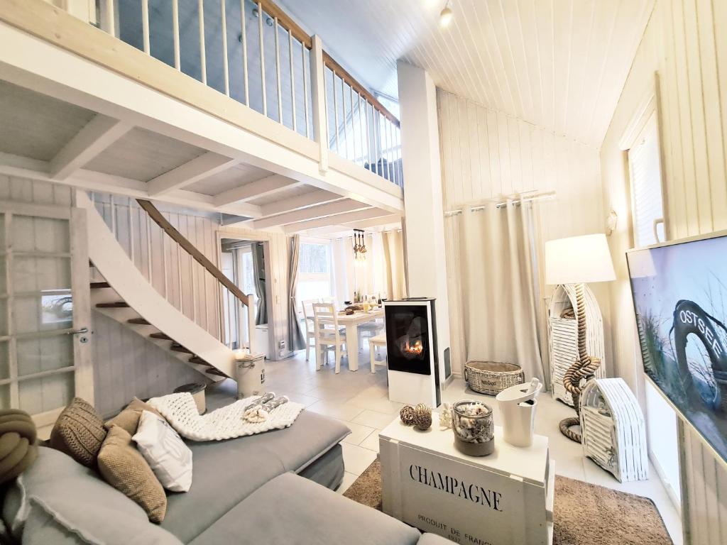 a living room with a couch and a staircase at Strandhaus Rügen - Sauna, Kamin, Whirlpool in Baabe