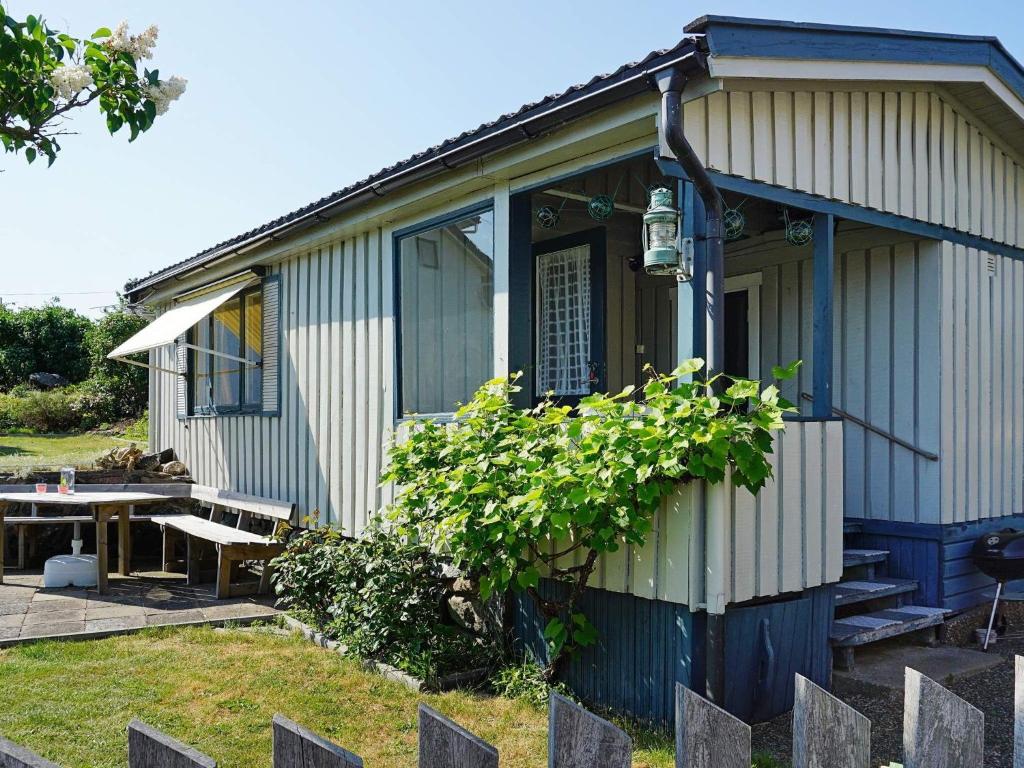 una pequeña casa con un banco y una mesa en 4 person holiday home in H n en Hönö