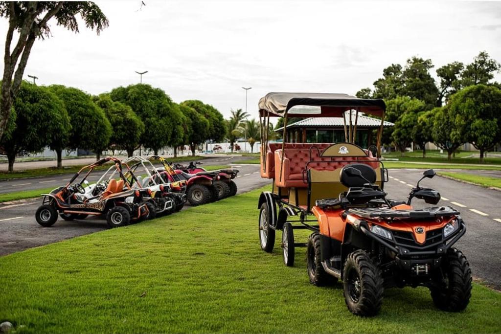 a group of atvs and a tractor parked on the side of a road at Hotel Fazenda Alto Alegre in Jaguaripe