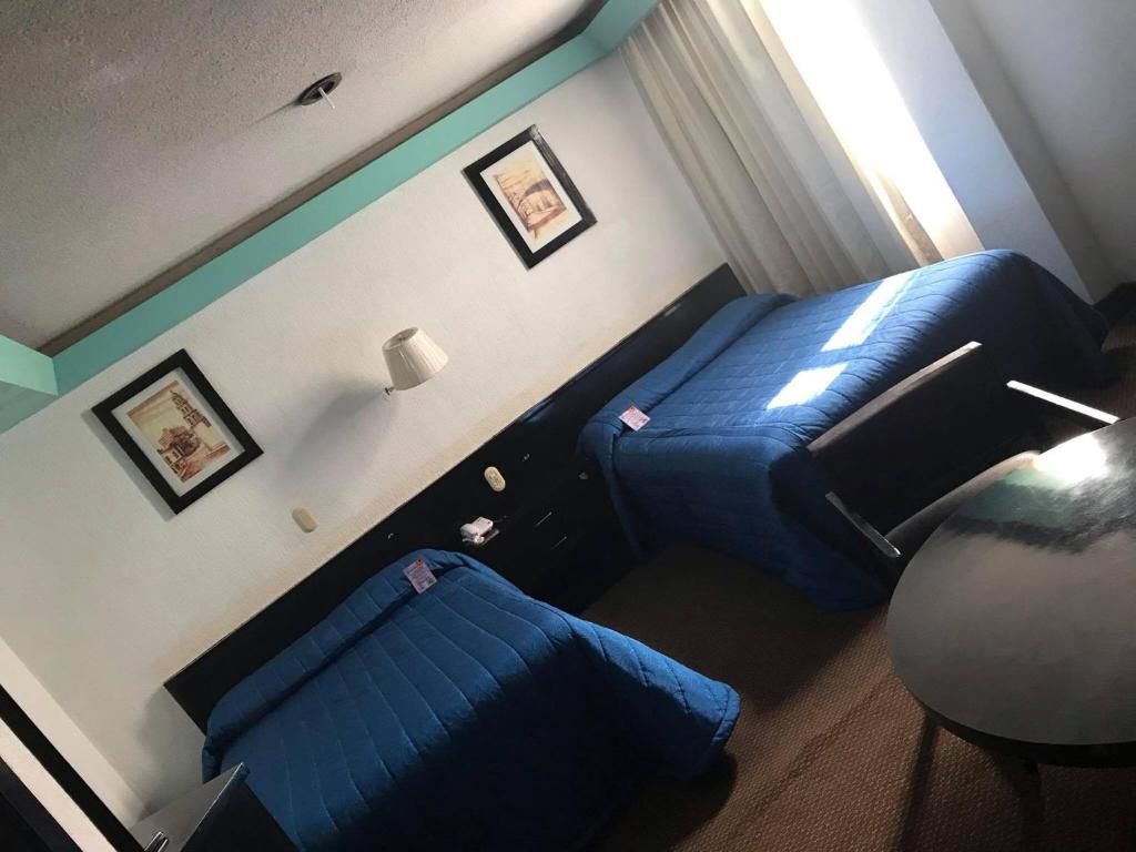 Postel nebo postele na pokoji v ubytování Hotel Real Rex