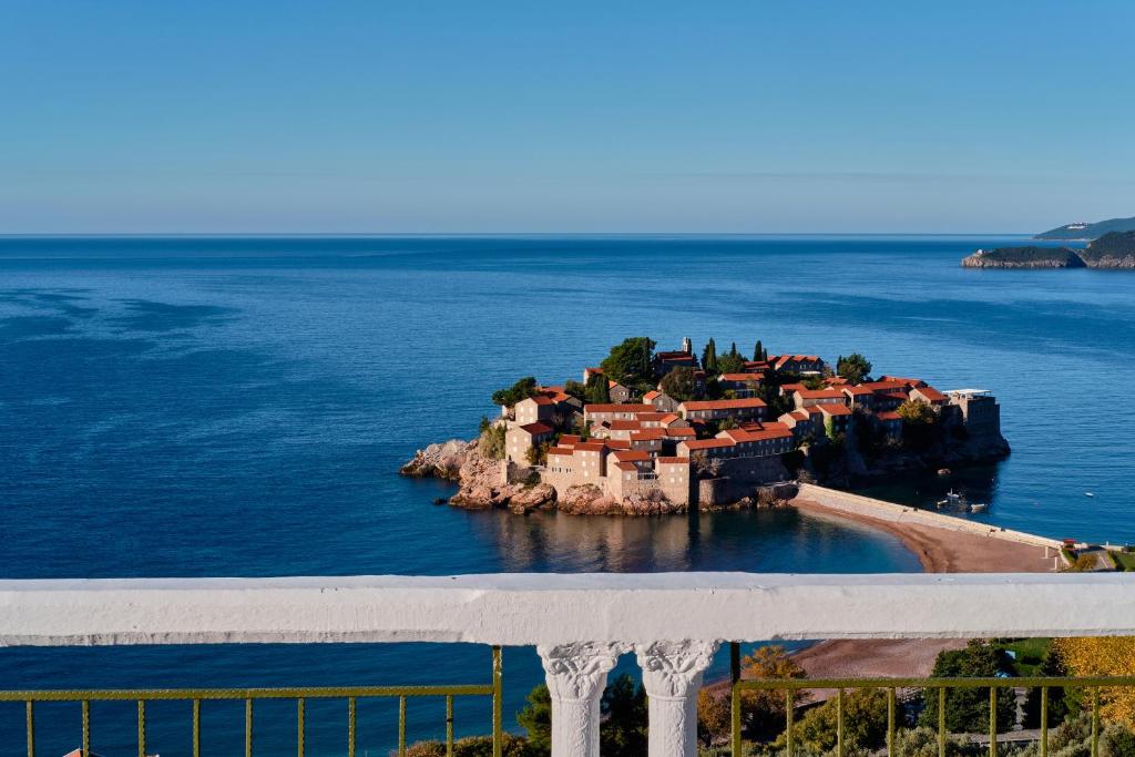 een klein eiland in het midden van het water bij Hotel Adrović in Sveti Stefan