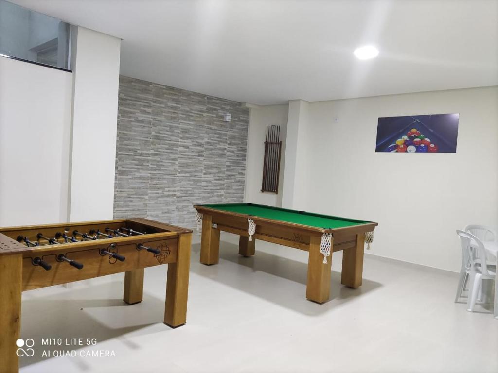 a room with two ping pong tables and a video game at Pousada das Letras in São Thomé das Letras