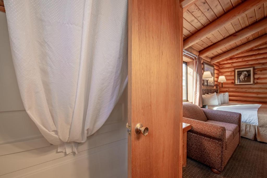 a bedroom with a bed and a couch in a room at Cowboy Village Resort in Jackson