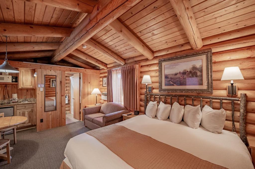 a bedroom with a bed and a chair in a room at Cowboy Village Resort in Jackson
