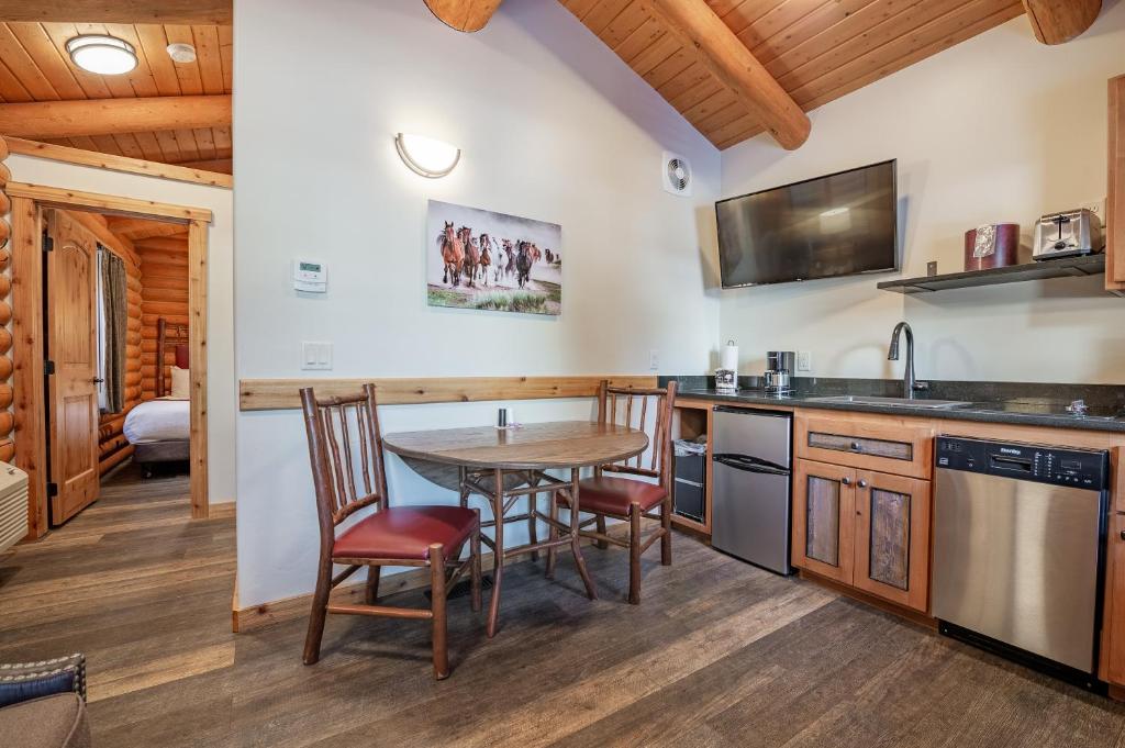 a kitchen with a table and chairs and a television at Cowboy Village Resort in Jackson