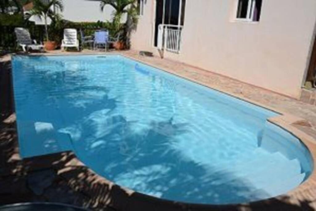舍爾謝的住宿－Appartement de Standing en Martinique，一座大蓝色游泳池,位于房子前