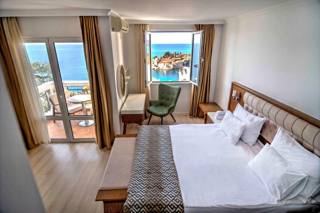 a hotel room with a bed and a view of the ocean at Hotel Adrović in Sveti Stefan