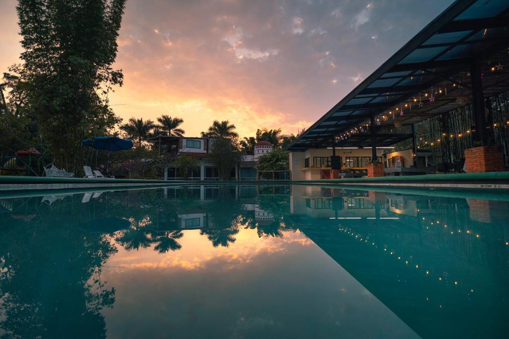a swimming pool with a sunset in the background at Hotel Quinta Moctezuma in Oaxtepec