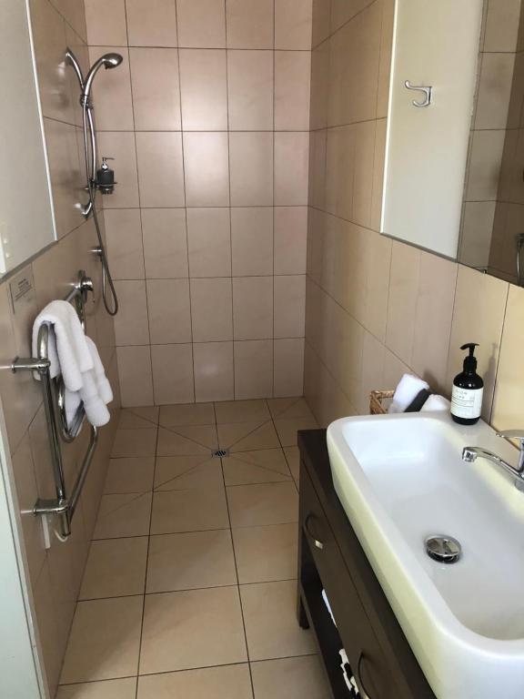 W łazience znajduje się umywalka i prysznic. w obiekcie Orokawa Bay Retreat w mieście Waihi