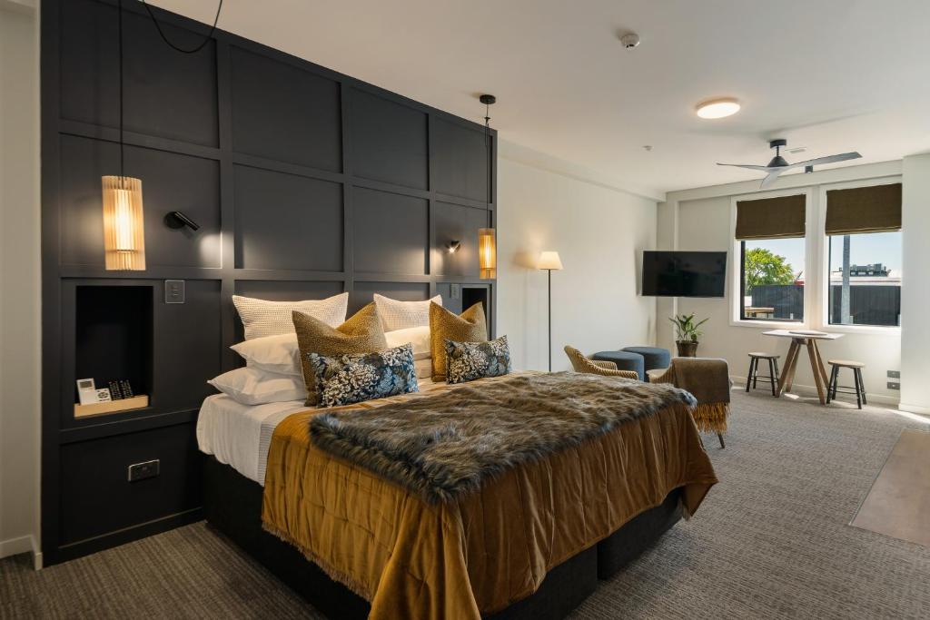 a bedroom with a large bed with a large headboard at 14th Lane Urban Hotel in Blenheim