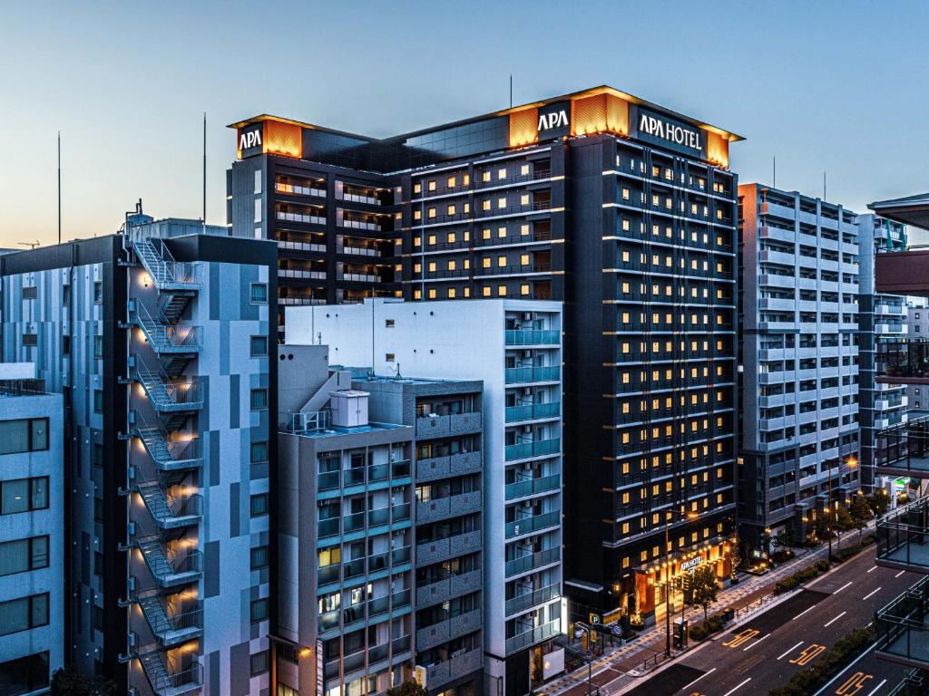 un edificio alto con luci sopra di APA Hotel Shin-Osaka Ekimae ad Osaka