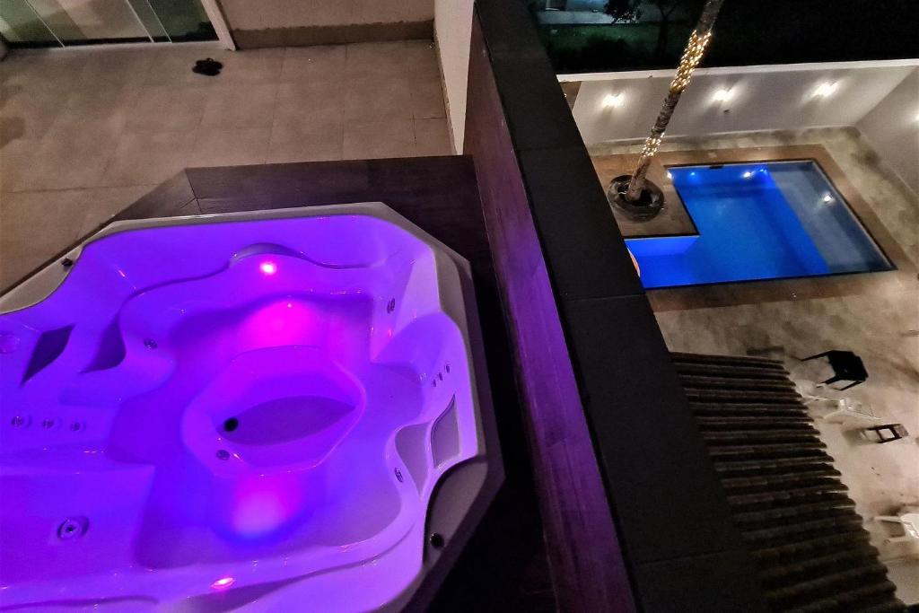 uma vista superior para uma banheira roxa com piscina em Marmeu Enseada com Hidro Aquecida Privativa no Guarujá