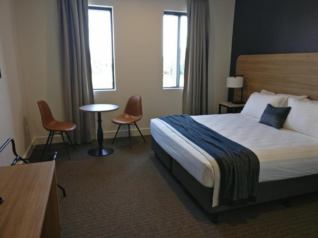 a hotel room with a bed and a table and chairs at Springs Newcastle in Newcastle