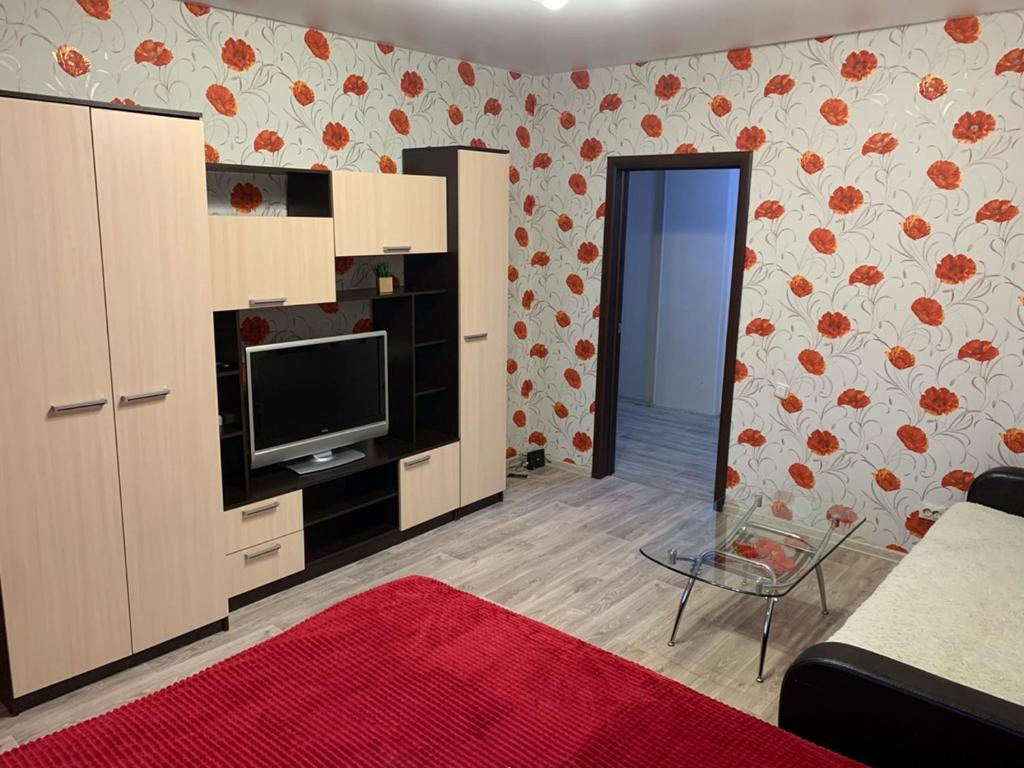 スルグトにあるУютная квартира на Захароваのリビングルーム(壁に薄型テレビ付)