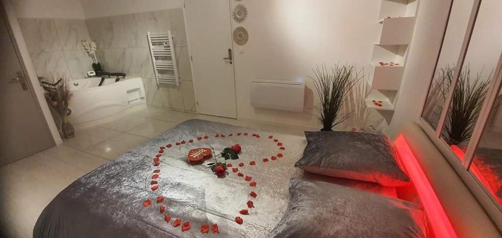 uma cama com um coração feito de rosas vermelhas em Love Rooms de la Presqu'île em Saint-Vincent-de-Paul