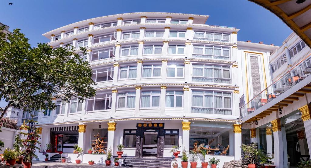 um grande edifício branco com um arco em frente em Durbar Hotel & Residence em Catmandu