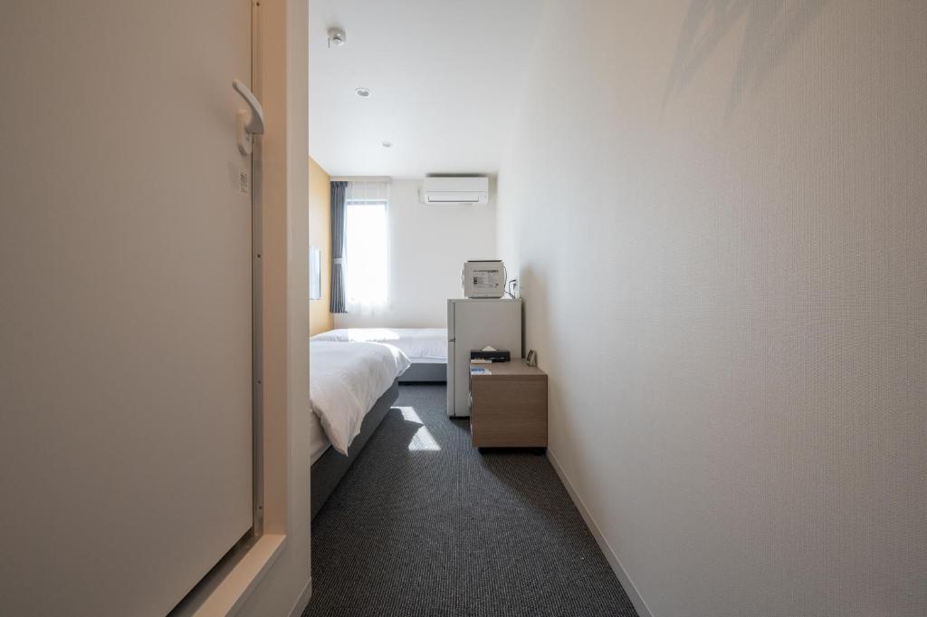 Postel nebo postele na pokoji v ubytování HOTEL R9 The Yard Sanotenjin