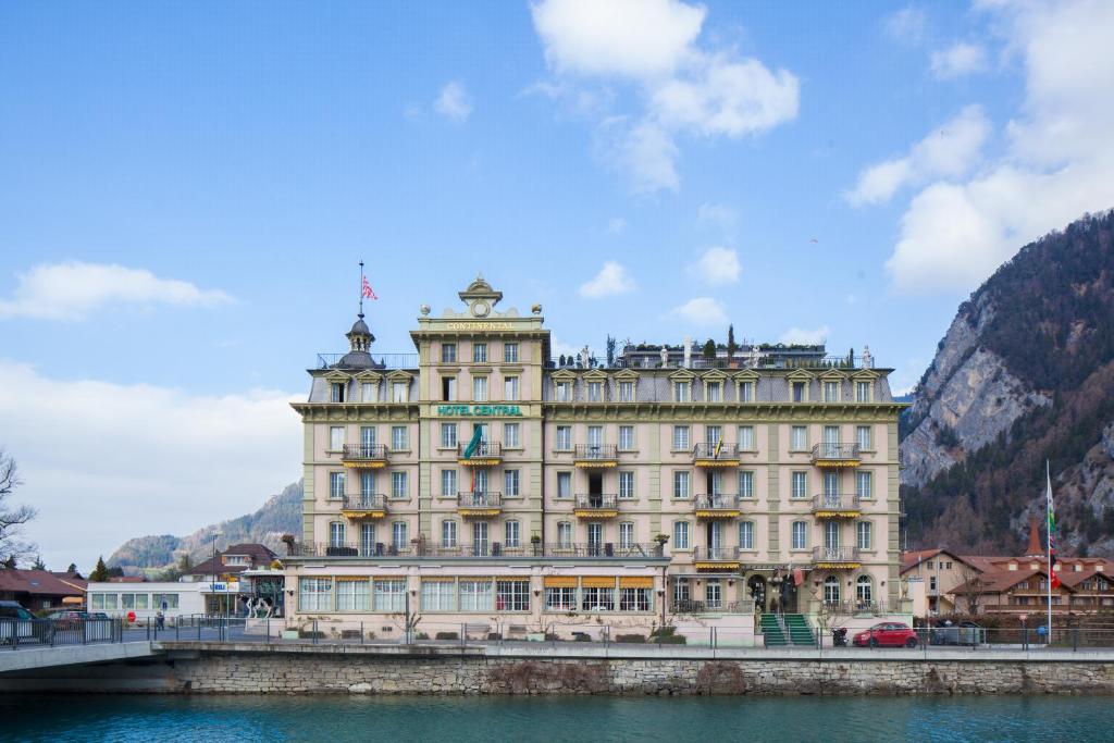 a large building on a bridge over a body of water at Hotel Central Continental in Interlaken