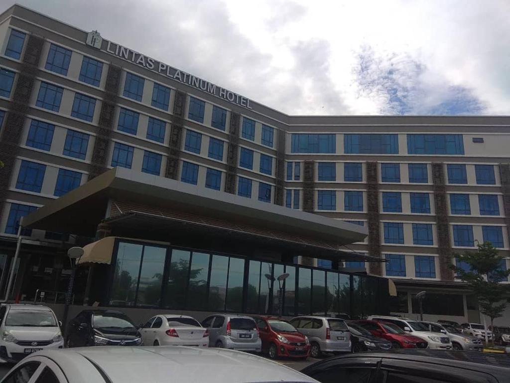 a large building with cars parked in front of it at Lintas Platinum Hotel in Kota Kinabalu